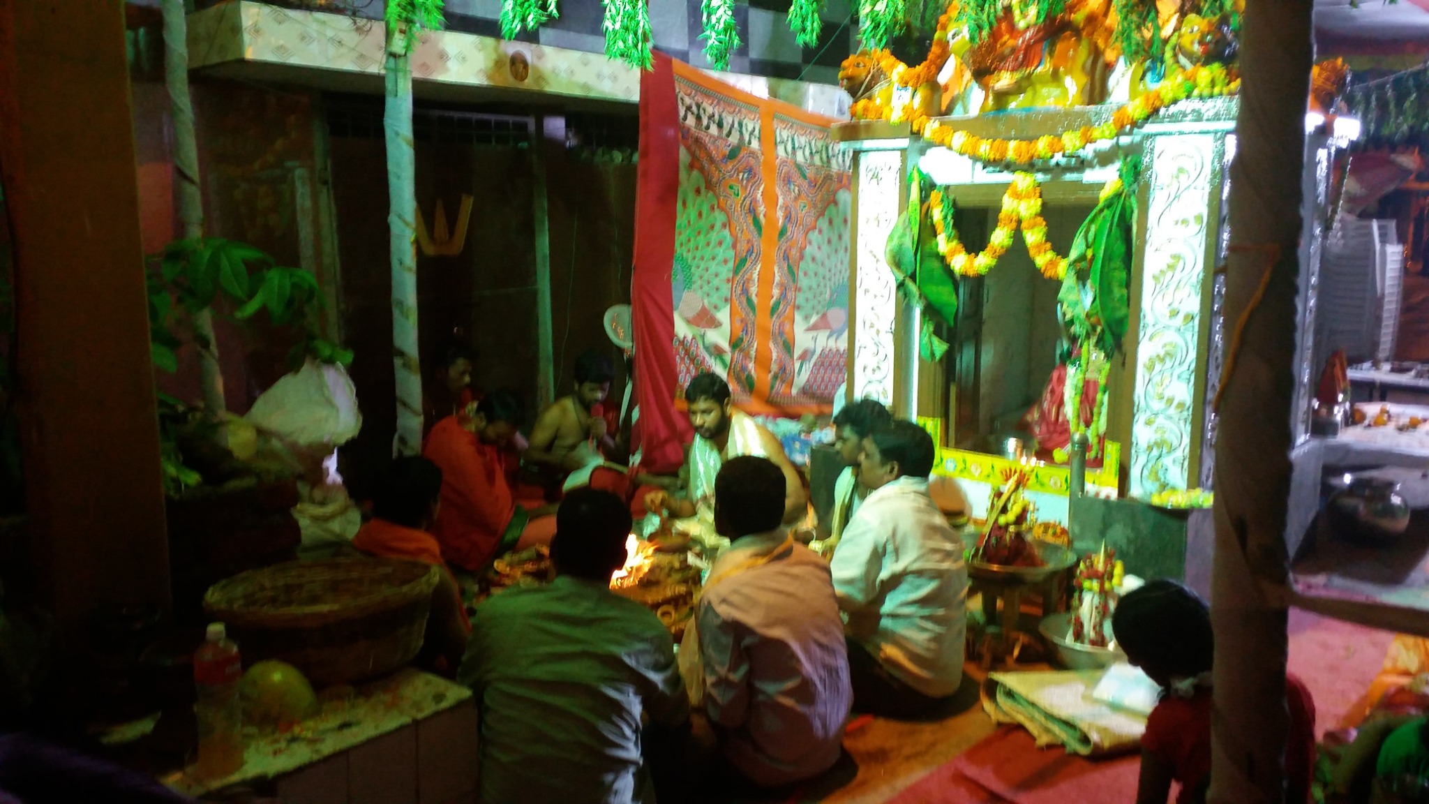 An early temple ritual with priests and devotees gathered before the sanctum