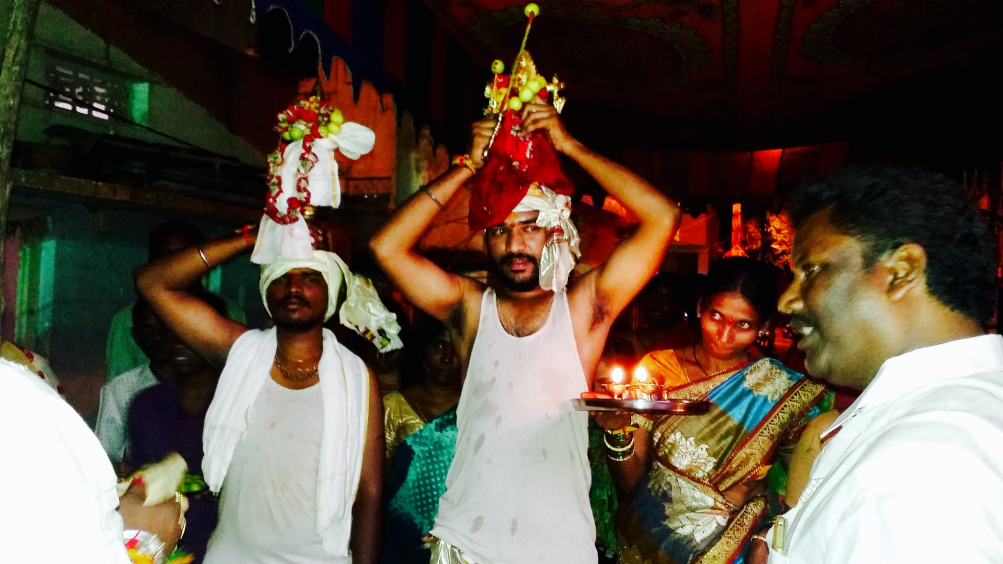 Devotees carrying sacred offerings in Amma's presence